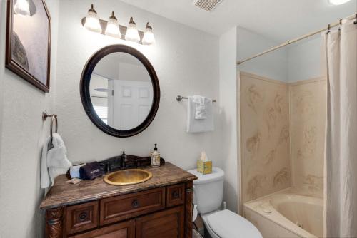 a bathroom with a sink and a toilet and a mirror at Baywatch C10 in Pensacola Beach