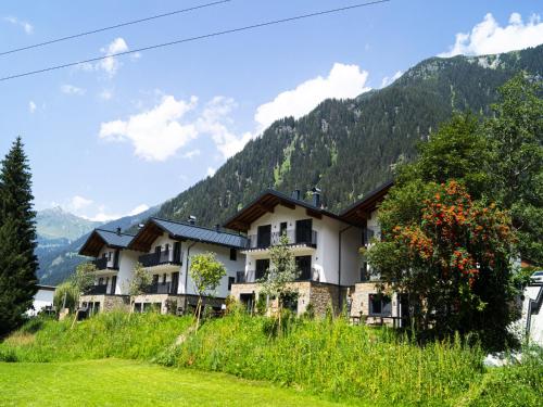 a building on a hill with mountains in the background at Graceful Chalet in Gaschurn with Sauna in Gaschurn