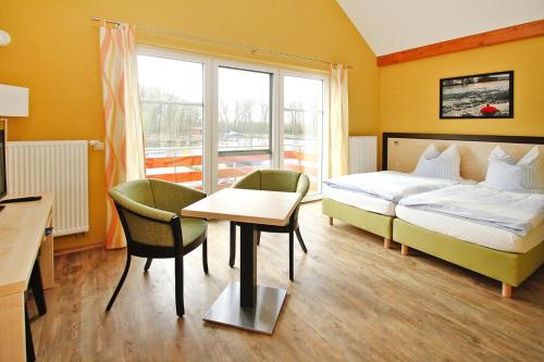 a hotel room with a bed and a table and chairs at Holiday apartment in the apartment house at the lighthouse, Plau am See in Plau am See