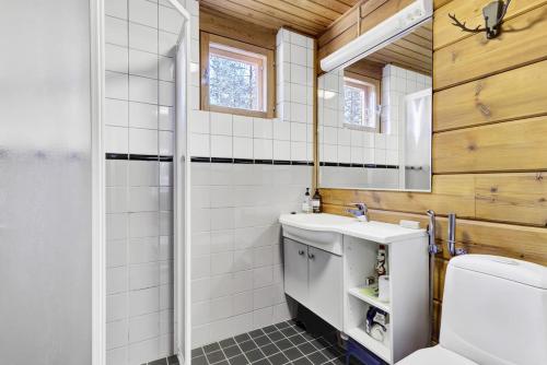 une salle de bain avec toilettes, lavabo et miroir dans l'établissement Villa Christina, à Pyhätunturi