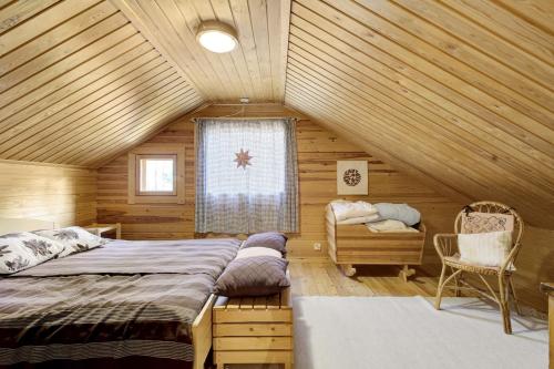 une chambre avec un lit dans une cabane en bois dans l'établissement Villa Christina, à Pyhätunturi