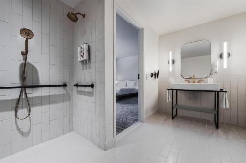 a bathroom with a shower and a sink and a mirror at Flamingo Resort & Spa Santa Rosa Sonoma, Tapestry by Hilton in Santa Rosa