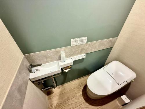 a bathroom with a toilet and a sink at Gouhou Garden Hotel Asakusa in Tokyo