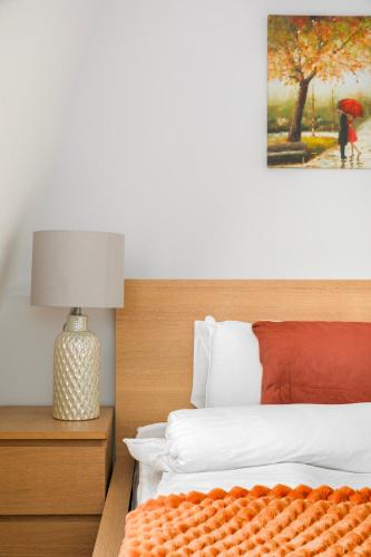 a bedroom with a bed and a lamp and a painting at Stylish Camden Town Apartments in London
