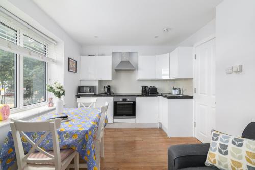 a kitchen and dining room with a table and chairs at Stylish Camden Town Apartments in London