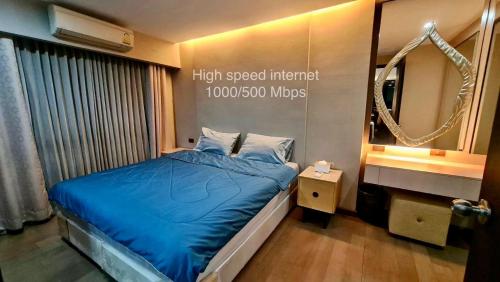 a small bedroom with a blue bed and a mirror at 1BR Thonglor , Fast WiFi , Near Samitivej , Nightlife in Khlong Toei