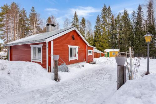 a small red house in the snow with trees at Woodside Home near Kungsberget in Jädraås