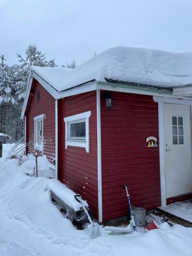 a red house with snow on top of it at Woodside Home near Kungsberget in Jädraås