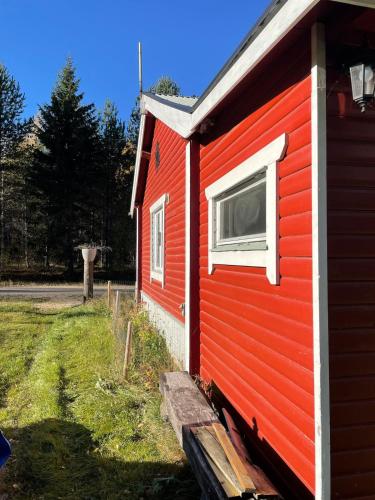 a red house with a window on the side of it at Woodside Home near Kungsberget in Jädraås