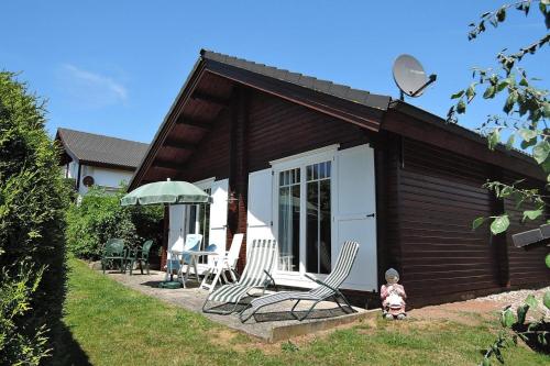 a little girl standing in front of a cabin at Cottage, Lissendorf in Lissendorf