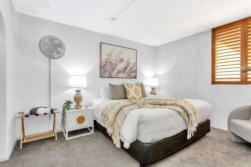 グレネルグにあるGlenelg Outlook - Beachfront Stay by Moseley Squareのベッドルーム1室(ベッド1台、壁掛け時計付)