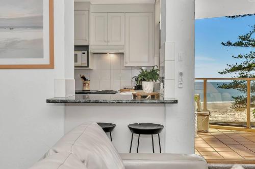 グレネルグにあるGlenelg Outlook - Beachfront Stay by Moseley Squareの部屋にカウンターとスツールがあるキッチン
