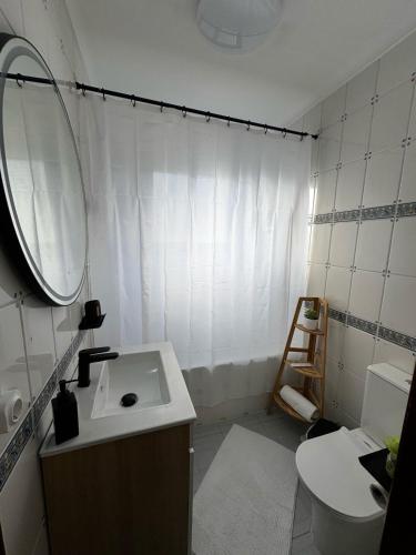 a bathroom with a sink and a mirror and a toilet at Casa da Vila in Vila Franca do Campo