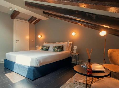 ein Schlafzimmer mit einem großen Bett und einem Tisch in der Unterkunft HOTEL VITE - By Naman Hotellerie in Rom