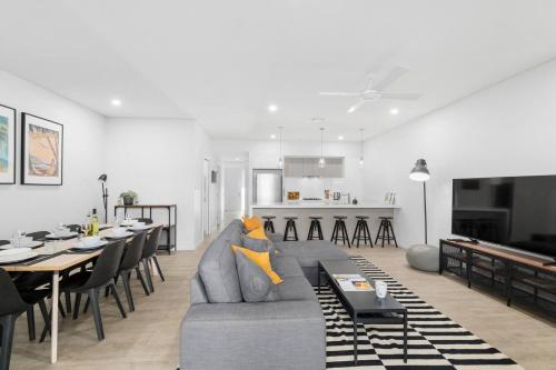 a living room with a couch and a dining room at Brigantine Escape - Harbourside Comfort near Beach in Shellharbour
