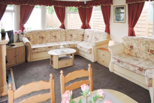 un salon avec un canapé et une table dans l'établissement Mobile home in Kolczewo with a terrace, à Kołczewo