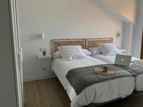 a bedroom with a bed with a laptop on it at Apartamentos Boutique Don Miguel in Noja