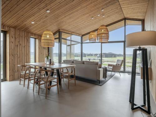 a dining room with a couch and a table and chairs at Lovely holiday home in Wissenkerke with garden in Wissenkerke