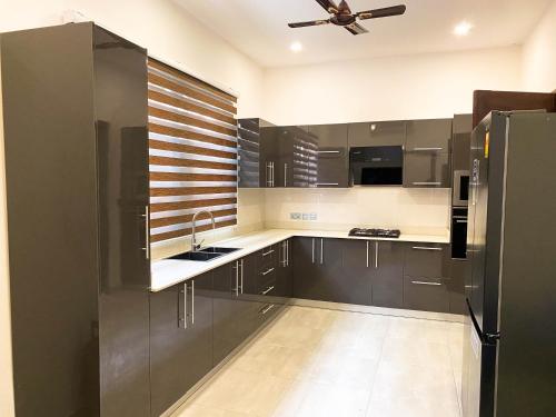 a kitchen with stainless steel appliances and a ceiling fan at Emmy's 3 Bedroom Apartment in Sakumona
