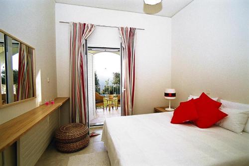 Un dormitorio con una cama con almohadas rojas. en Apartment in Residence Rodanthi, en Darmarochori