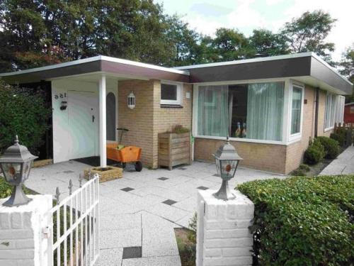 a small house with a white fence in front of it at Pretty home in Sint Maartenszee in Sint Maartenszee