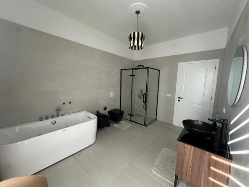 a bathroom with a tub and a toilet and a sink at Le stanze della luna in Kamëz