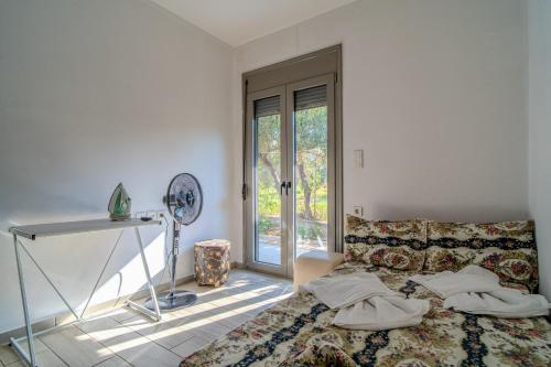 a bedroom with a bed and a table and a window at Cretan Blue Bungalow Chania in Chania
