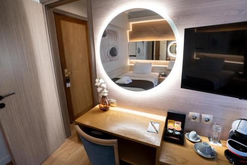 a room with a desk with a mirror and a bed at Coral Hotel Athens in Athens