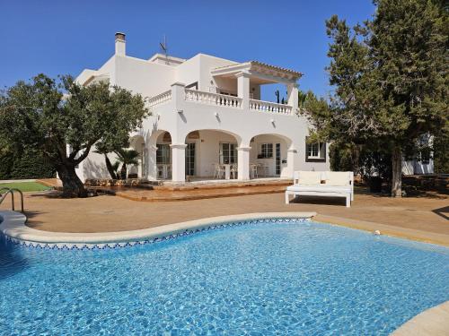 a villa with a swimming pool in front of a house at INIBIZA VILLAS - Villa Oasis in Sant Jordi