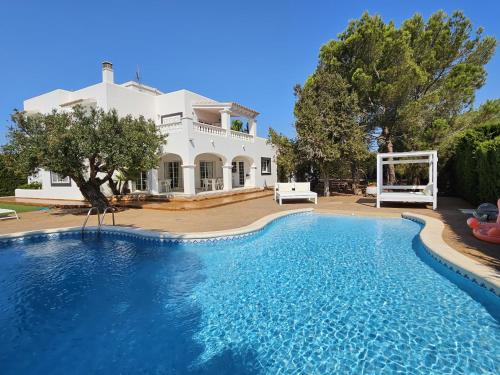 a large swimming pool in front of a house at INIBIZA VILLAS - Villa Oasis in Sant Jordi