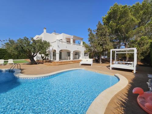 a villa with a swimming pool in front of a house at INIBIZA VILLAS - Villa Oasis in Sant Jordi
