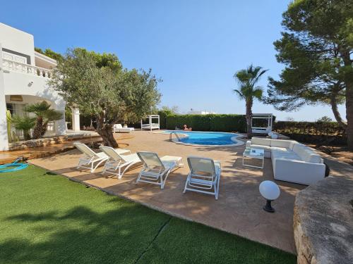 a yard with chairs and a swimming pool at INIBIZA VILLAS - Villa Oasis in Sant Jordi