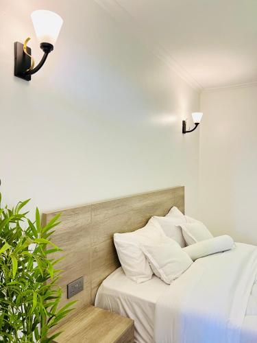 カンパラにあるModern apartment with Balcony, Kampalaのベッドルーム1室(白いシーツと照明2つ付)
