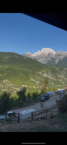 a parking lot with parked cars and mountains in the background at Guesthouse Zhari in Theth