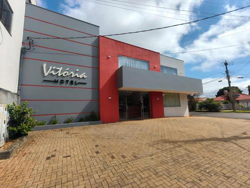 a white and red building with a sign on it at Hotel Vitória - Guaíra in Guaíra