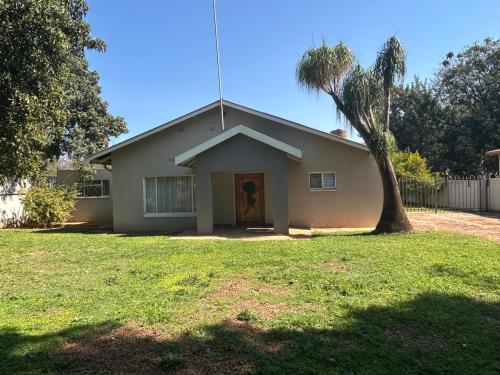 ein kleines Haus mit einem Baum im Hof in der Unterkunft C'est Si Bon Accommodation at 73 Geyser, Mokopane in Mokopane