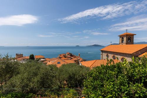 una iglesia con una torre de reloj junto al océano en Lamar Residenza al Mare di Tellaro, en Lerici