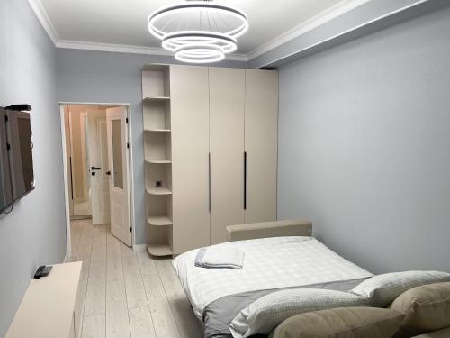 Un dormitorio blanco con una cama y un armario. en ЖК Millennium, en Bishkek