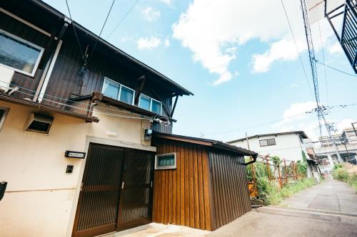 a building with a wooden gate next to a street at Restelle - JR Nara 2min Max 7 guests in Nara