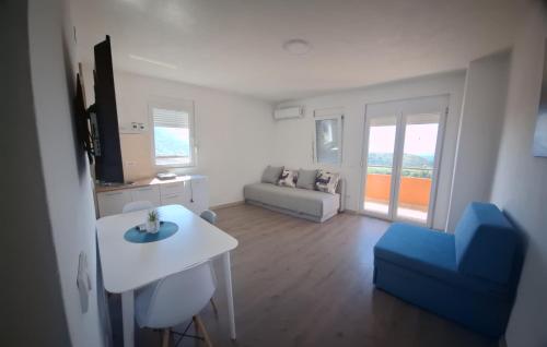 a living room with a white table and a blue chair at Apartmani Seaview in Sutomore