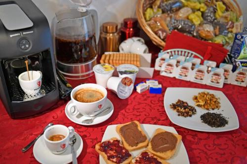 een tafel met borden eten en kopjes koffie bij Sole Abano Terme in Abano Terme