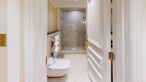 a white bathroom with a toilet and a shower at Cheval Thorney Court at Hyde Park in London