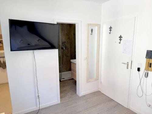 ein Zimmer mit einem Fernseher auf einem weißen Schrank in der Unterkunft Cozy Studioapartment in Würzburg