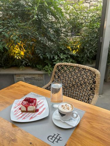 a table with a piece of cake and a cup of coffee at Piccadilly House in Arta