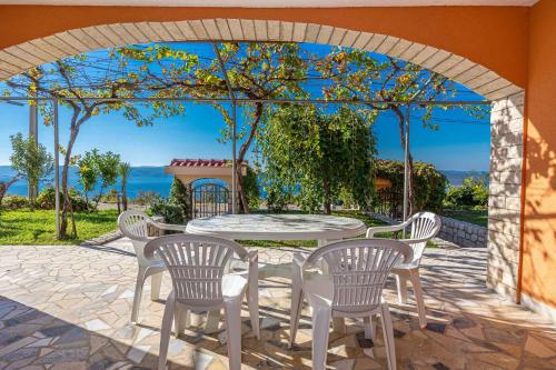 a patio with a table and chairs under an arch at Apartments in Crikvenica 43070 in Barci