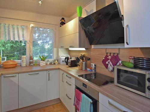 a kitchen with white cabinets and a microwave at Welcoming Family Escape in Güntersberge