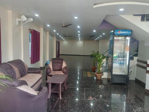 a lobby with two couches and a drink machine at Hotel Regal Heights in Deoghar