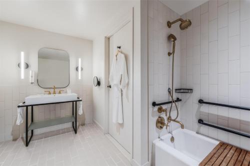 a bathroom with a tub and a sink and a mirror at Flamingo Resort & Spa Santa Rosa Sonoma, Tapestry by Hilton in Santa Rosa