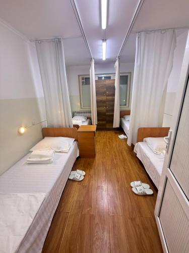 a room with two beds and slippers on the floor at Time hostel in Osh