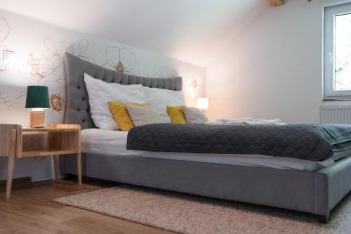 a bedroom with a large bed with yellow pillows at Penzion Medové údolí in Čábuze